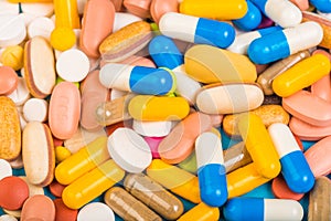 Set of multi-colored tablets and capsules on a blue background