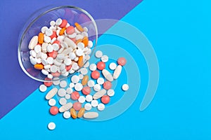 Set of multi-colored tablets and capsules on a blue background