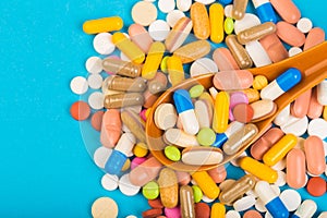 Set of multi coloured tablets and capsules on a blue background
