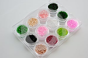Set of multicolored beads for embroidery and needlework in plastic jars
