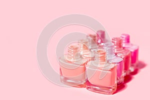 Set of nail polish bottles. Group of nail polish isolated on pink background. Copy space