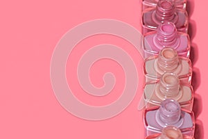 Set of nail polish bottles. Group of nail polish isolated on pink background. Copy space