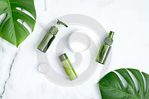 Set of natural organic cosmetics with green tropical leaves. SPA beauty products for skincare, body and hair care. Flat lay, top
