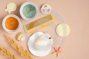 Set of natural organic SPA cosmetics on peach background. Clay facial masks, homemade soap, loofah and sponge on peach background