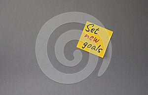 Set New Goals symbol. Concept words Set New Goals on orange steaky note. Beautiful grey background. Business and Set New Goals