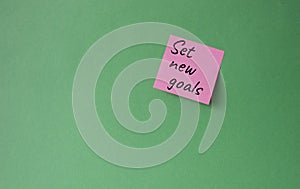 Set New Goals symbol. Concept words Set New Goals on pink steaky note. Beautiful green background. Business and Set New Goals