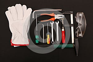 A set of new hand tools, mask, glasses and gloves on a black background