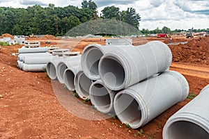 Set of new pipes stacked on yellow clay at a construction site
