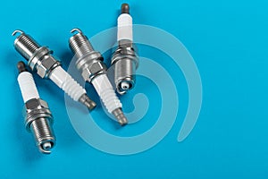A set of new spark plugs a blue background