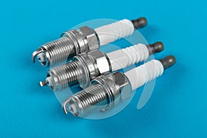 A set of new spark plugs a blue background