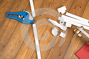 Set of objects and tools for assembling water pipes on a wooden floor background