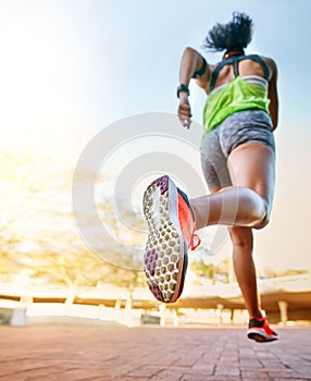 Set off and conquer your goals. Rear view shot of a sporty young woman out for a run.