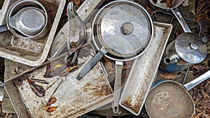 A set of old baking trays utensils pots and pans in a childs outdoor mud kitchen