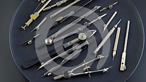 Set of old different compasses. Retro metal compasses and drafting tools on a black background. Drawing pen.