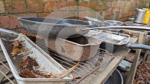 A set of old rusty pots and pans in a childs outdoor mud kitchen