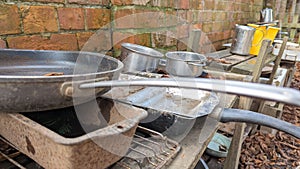 A set of old rusty pans and pots in a childs outdoor mud kitchen