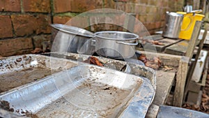 A set of old rusty trays and pots in a childs outdoor mud kitchen