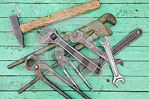 Set of old tools. Green painted wooden background