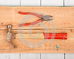 Set of old tools hammer and pliers on wooden background