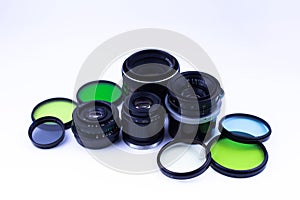 A set of old-vintage lenses and color photo filters on a white background