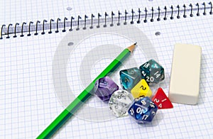 Set of open exercise book, pencil, rubber and dices on