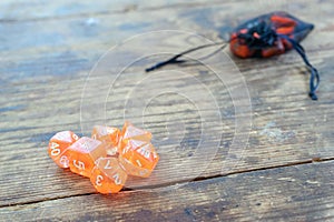 Set of orange color dice for many role playing and board games, dnd and rpg on vintage wooden table