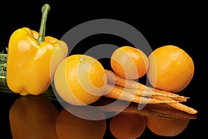 Set of orange fruits-mandarin,orange,carrots on black at the bottom