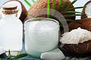 Set of organic coconut products for spa, cosmetic or food ingredients decorated palm leaves. Natural oil, water and shavings.