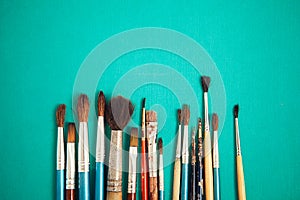 Set of paint brushes on the turquois background