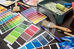 Set of paint tools as  color paper palette guide, blue gloves and brush on wooden board