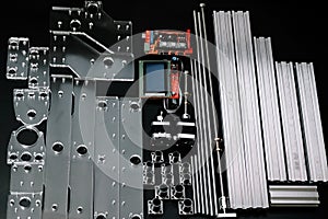 a set of parts for a laser machine on a black background, silver backlight, flat lay arduino board for controlling the machine and