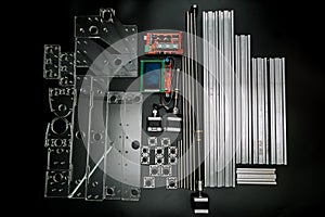 A set of parts for a laser machine on a black background, silver backlight, flat lay arduino board for controlling the machine and