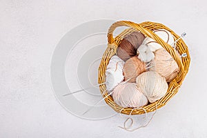 A set of pastel clew of thread for knitting in a basket. Handmade, hobby, crochet concept