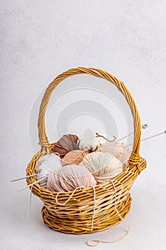 A set of pastel clew of thread for knitting in a basket. Handmade, hobby, crochet concept