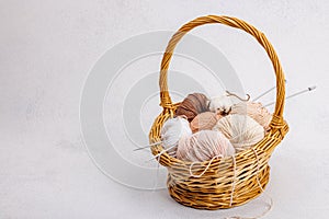 A set of pastel clew of thread for knitting in a basket. Handmade, hobby, crochet concept