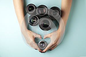 Set of photo lenses on a colored background, the selection and comparison of photographic equipment, hands are holding photo