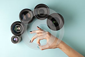 Set of photo lenses on a colored background, the selection and comparison of photographic equipment, hands are holding photo