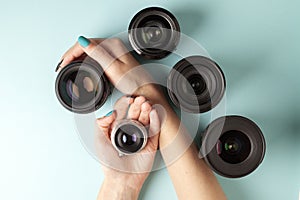 Set of photo lenses on a colored background, the selection and comparison of photographic equipment, hands are holding photo