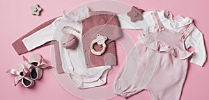 Set of pink clothes and accessories fot newborn girl. Toys, bodysuit, romper, knitted cardigan, shoes, bib on pastel