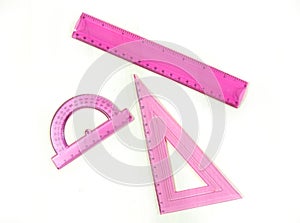 Set of pink measuring tools: rulers, triangles, protractor. Correct form and sizes. Metric system of measurements: centimeters and