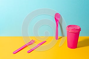 Set of pink plastic fork, knife and spoon, and paper coffee cup