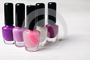 Set of pink and violet colorful nail polish bottles