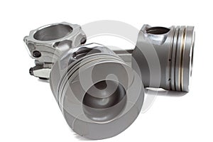 A set of pistons and rods for automobile engine on a white background