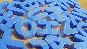 Set of plastic alphabet letters placed on a wooden floor