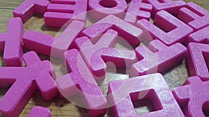 Set of plastic alphabet letters placed on a wooden floor