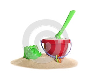 Set of plastic beach toys and pile of sand on white