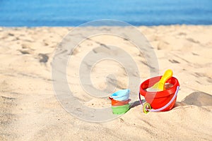 Set of plastic beach toys on sand near sea. Space for