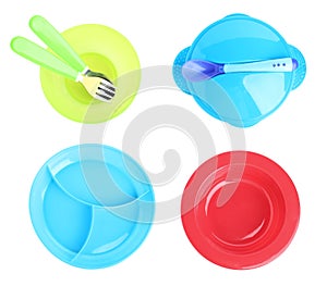 Set of plastic dishware for baby food on background, top view