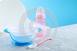 Set of plastic dishware on grey table. Serving baby food