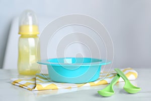 Set of plastic dishware on white table. Serving baby food